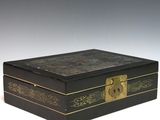 une boîte noire ornée de dorures et dotée d'une serrure sur le couvercle