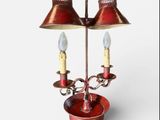 a red table lamp with two lamps on top of it