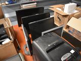 a lot of computer monitors and other electronics in a room