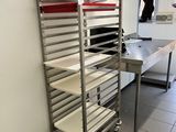 une étagère métallique sur laquelle sont disposés de nombreux plateaux de nourriture