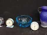 un vase en verre bleu, un bol en verre bleu, une montre en verre bleu et un vase en verre bleu