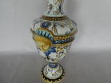 a vase with a bird on it sitting on a table