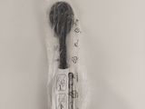 a close up of a toothbrush in a plastic bag on a white surface