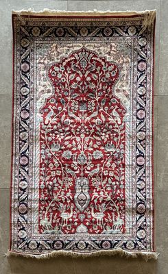 un tapis rouge et noir accroché au mur d'une pièce