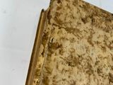 an old book sitting on a table with a white background