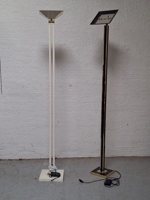 two floor lamps that are standing next to each other
