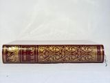 a red and gold book sitting on a white table