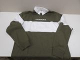 green and white long sleeved shirt sitting on top of a white table
