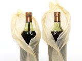 two bottles of wine wrapped up in plastic bags