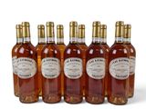 six bouteilles de vin sont alignées sur une surface blanche