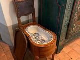 des toilettes avec un siège en bois, à côté d'une porte verte