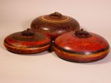 three red and brown ceramic containers sitting on top of a white surface