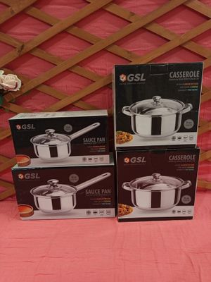 three sets of stainless steel pots and pans on a pink table cloth