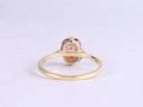 a yellow gold ring with a pink tourmaline stone in the center