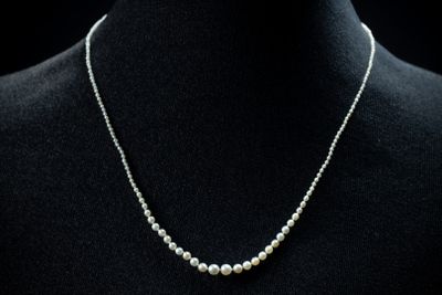 un collier de perles blanches sur un mannequin mannequin mannequin mannequin mannequin mannequin mannequin mannequin mannequin mannequin