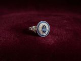 un gros plan d'une bague posée sur un fond de velours rouge