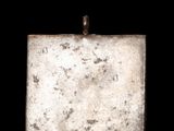 a small square silver object with a black background