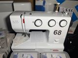 a white sewing machine sitting on a table with other sewing supplies