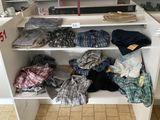 une armoire blanche sur laquelle sont posés de nombreux vêtements