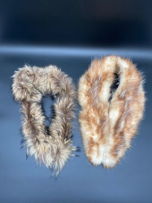 two pairs of furry slippers are shown on a black surface