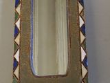 a small mirror sitting on a table next to a wall