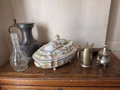 une commode sur laquelle sont disposés de nombreux objets anciens