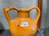 un vase jaune posé sur une table, avec une étiquette de prix dessus