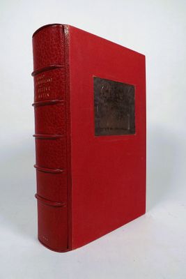 a red book sitting on top of a white table next to a white wall