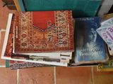 a pile of books sitting on the floor next to a clock