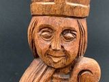 a close up of a wooden statue of a man holding a baby