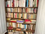 a book shelf with many books on it in a room