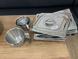 a lot of stainless steel pans on a wooden table