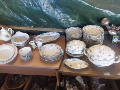 de nombreuses assiettes et bols posés sur une table recouverte d'une bâche verte