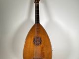 a small wooden instrument on a stand on a white surface