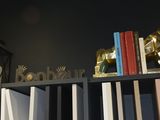 a book shelf with books and a lamp on it