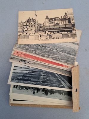de nombreuses vieilles photos dans une boîte en carton posée sur une table