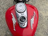 a close up of a red motorcycle with a clock on it
