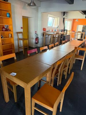 tables and chairs in a room with a bookcase and a ceiling fan