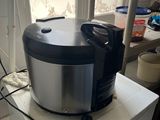 a silver and black food processor sitting on top of a white refrigerator