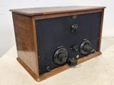 an old fashioned radio sitting on top of a wooden table
