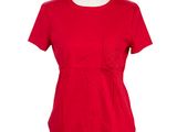 le haut rouge est posé sur un mannequin dont la base est blanche