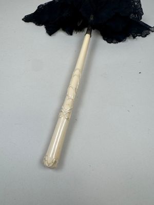 a black lace umbrella with a wooden handle on a table