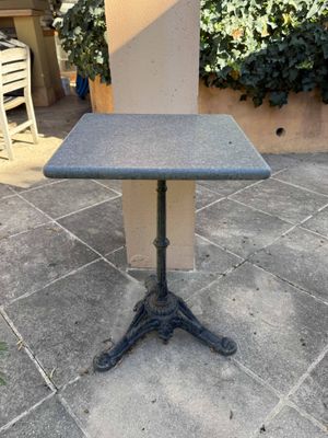 an outdoor table sitting on a patio next to a chair