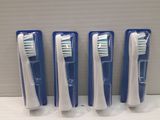 Quatre brosses à dents bleues et blanches sont alignées sur une étagère