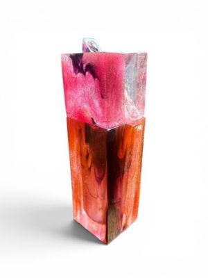 a pink and red soap bar sitting on a white surface