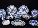des assiettes et des bols en porcelaine bleue et blanche sur fond noir