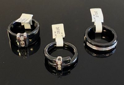 trois anneaux munis d'étiquettes, posés sur une surface noire