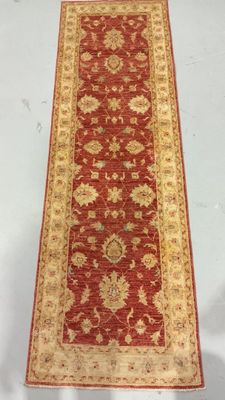 a red and gold runner rug on a white background