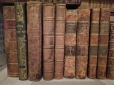 a lot of old books on a shelf in a library