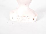 a small white vase with a flower in it on a white surface